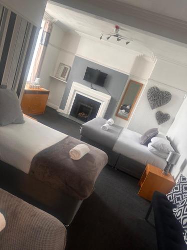 a hotel room with two beds and a fireplace at Sheridans hotel in Wallasey