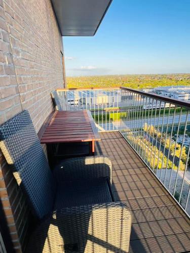 a balcony with a wooden table and bench on a building at Ama Hyg Atelier Copenhagen Royal Arena 2 Bedrooms Apartment in Copenhagen