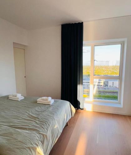 a bedroom with a bed and a large window at Ama Hyg Atelier Copenhagen Royal Arena 2 Bedrooms Apartment in Copenhagen