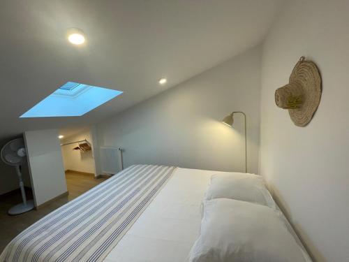 a bedroom with a large bed with a skylight at Appartement - Hossegor Lac in Hossegor
