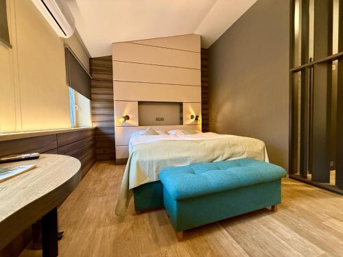 a bedroom with a bed and a blue ottoman at ANPELA in Rýmařov
