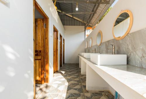a bathroom with three sinks and two mirrors at Nongkhiaw IngIng Backpackers Hostel in Nongkhiaw