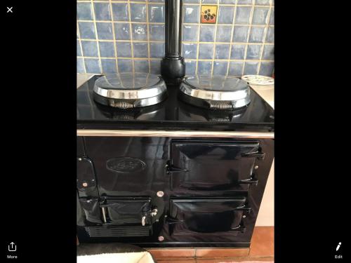 a stove with two pots and pans on top of it at Gwynarth B&B in Wadebridge