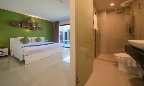 a bedroom with a bed and a bathroom with a shower at Gu Hotel Patong in Patong Beach