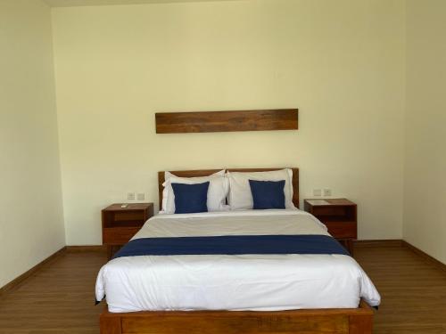 a bedroom with a large bed with blue pillows at Villa Daisy Private Pool in Tanah Lot