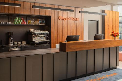 la hall di un ristorante con un bancone con due computer portatili sopra di City Inn Hotel Olomouc a Olomouc