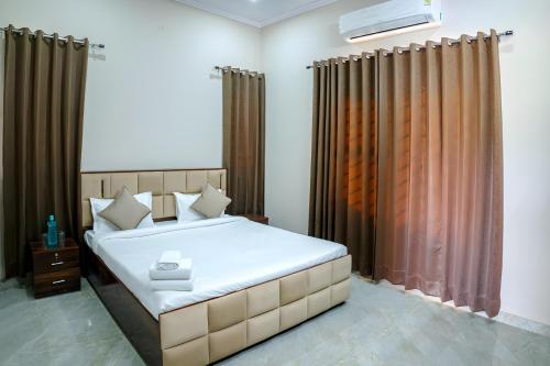 a bedroom with a large bed with brown curtains at Silverleaf Homestay in Borāj