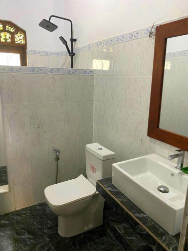 a bathroom with a white toilet and a sink at Sylt Haus in Beruwala