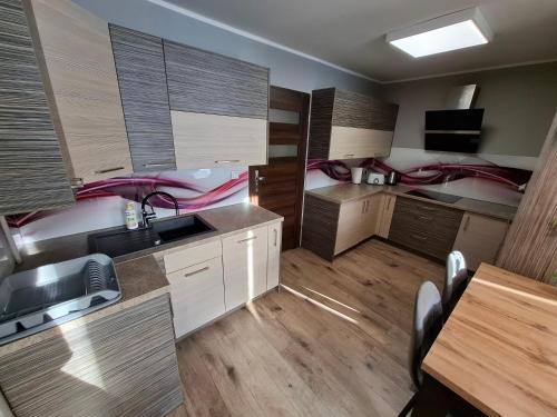 a kitchen with wooden floors and cabinets and a sink at Apartament Lewin Kłodzki in Lewin Kłodzki