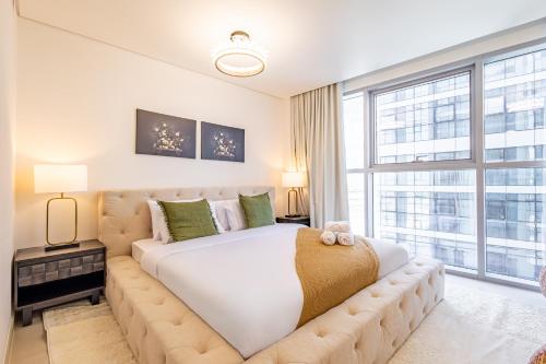 a bedroom with a large bed and a large window at Full Sunset Canal Views - Amazing Apartment in the Heart of Al Reem - 5 min from Cleveland, Galleria, ADGM in Abu Dhabi