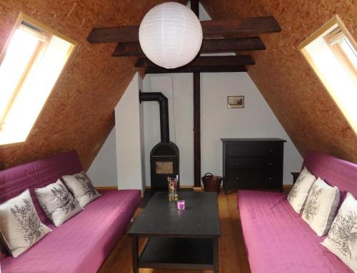 a living room with two purple couches and a table at Herberge Landstreicher in Königstein an der Elbe