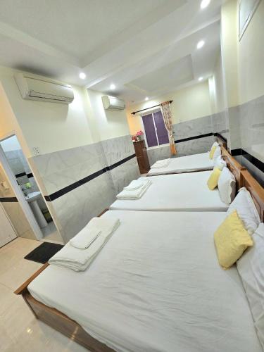 a group of four beds in a room at Hoang Chau Motel in Vung Tau