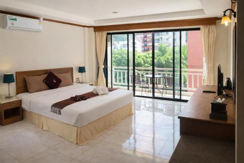 a bedroom with a large bed and a balcony at Global Hotel Beach View in Patong Beach