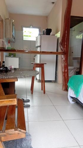a kitchen with a table and a refrigerator at Casa do Carlos Boipeba 2 in Cairu