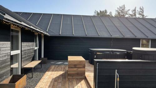 a patio with a bar and a grill on a house at Villavilla 637 - Vorupør, Nordjylland in Stenbjerg