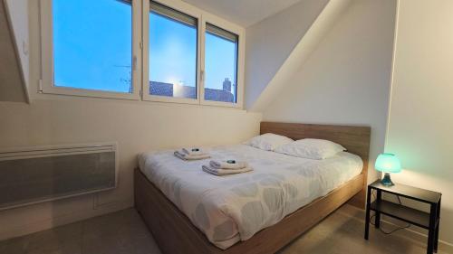 a bedroom with a bed with two towels on it at Studio Foch 4 in Grand-Fort-Philippe