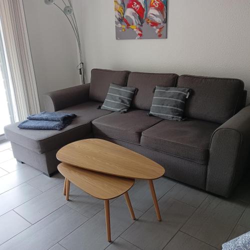 a living room with a brown couch and a table at La casa du creux in Valras-Plage