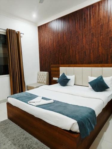 a bedroom with a large bed with a wooden wall at HOTEL JVS PALACE in Gorakhpur