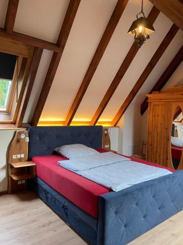 a bedroom with a blue bed in a attic at Ferienhaus Sprejnik Bautzen in Bautzen