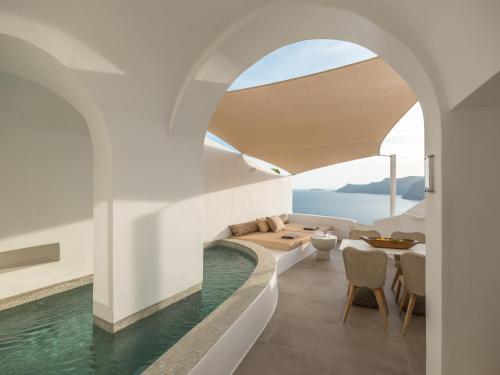 salon z basenem i stołem w obiekcie Aspaki by Art Maisons w mieście Oia