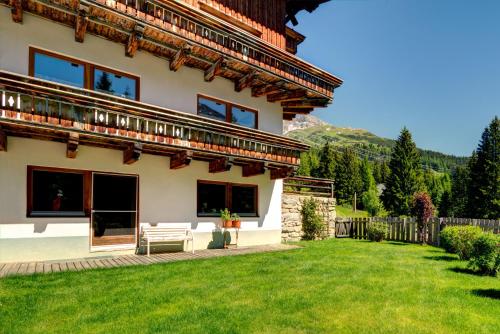 a house with a green lawn in front of it at Pension Sattelkopf in Sankt Anton am Arlberg