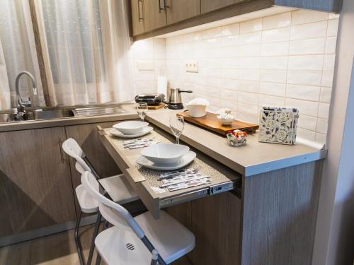 a kitchen with a counter with two chairs and a sink at Alkiones in Platy
