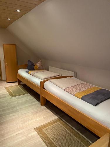 two twin beds in a room with a wall at Münsterblick in Wolframs-Eschenbach