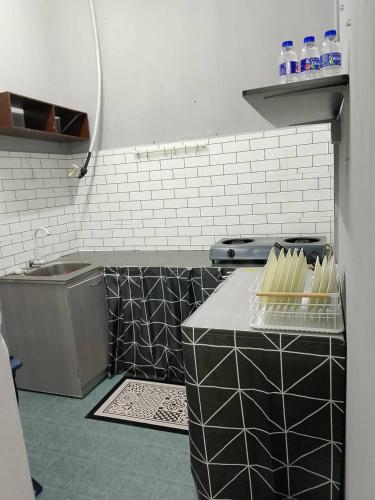 a kitchen with black and white tiles and a counter at Tipika Guest House - di Pasir Pekan sempadan 3 Daerah KB, Pasir Mas & Tumpat in Tumpat