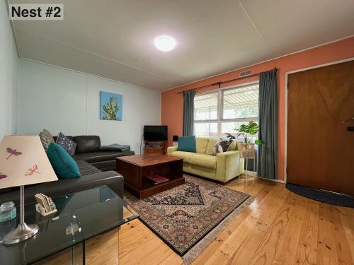 a living room with a couch and a table at Grampians Nest in Halls Gap