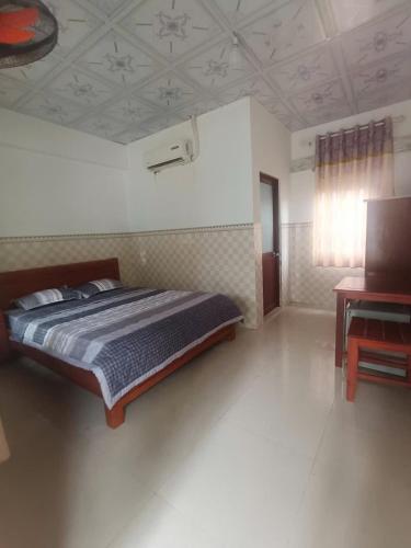 a bedroom with a bed and a desk in it at Homestay Mỹ Ánh 1 in Phú Quốc