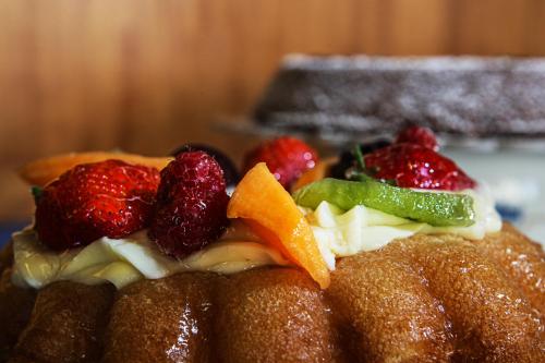 a cake with fruit on top of it at Hotel Max in Aversa