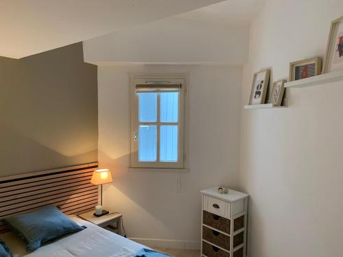Maisonnette de Charme في Les Portes: غرفة نوم بها سرير ونافذة