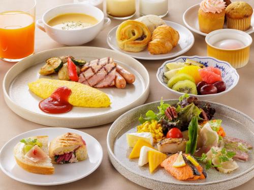 a table topped with plates of food and drinks at Solaria Nishitetsu Hotel Fukuoka in Fukuoka