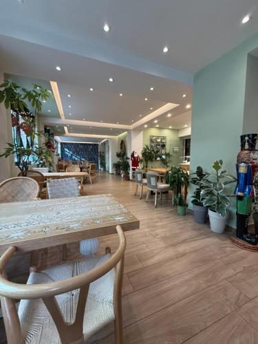 een lobby met een tafel en stoelen en potplanten bij The Maroon Bottle Luxury Suites in Thessaloniki
