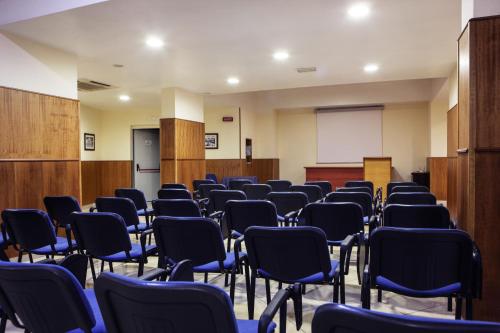 a room with rows of chairs in a classroom at Hotel Max in Aversa