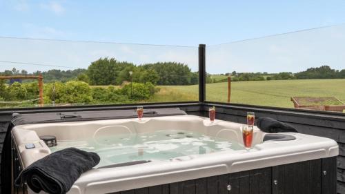 a jacuzzi tub with a view of a field at Villavilla 546 - Hostrup Strand, Limfjorden in Spottrup