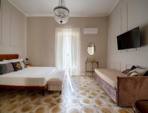a bedroom with two beds and a flat screen tv at Ziolì Apartment in Noto