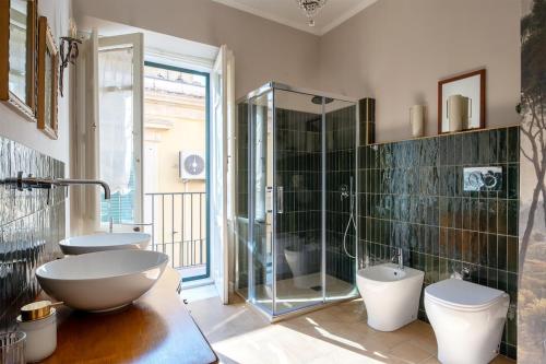 a bathroom with a shower and a sink and a toilet at Ziolì Apartment in Noto