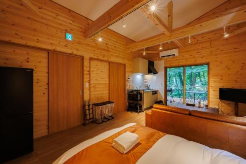 a bedroom with a bed and a television in a room at Narusawa MADOKA in Narusawa