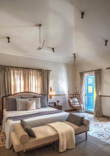 a bedroom with a large bed and a swing at LohonoStays Castello Villa 2 in Assagao
