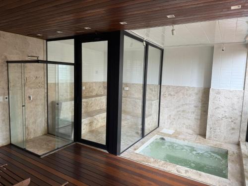 a bathroom with a tub and a glass shower at Luxo e Aconchego 1Qt Com Sacada GY03 proximo Vaca Brava in Goiânia