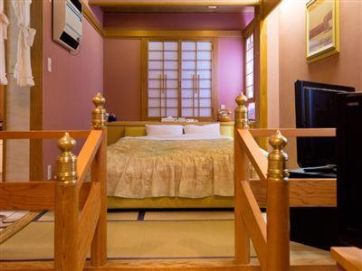 a bedroom with a large bed with a window at ホテルツクバランド in Tōgane