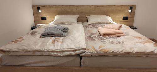 a large bed with two pillows and towels on it at MaxLux Apartments in Slovenj Gradec