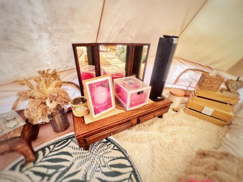 un tavolo con cosmetici e altri oggetti su un letto di LOVE ROOM Tente chauffée Lodge spa MFG chez C&C, exclusivement réservée aux ADULTES a Cantaron
