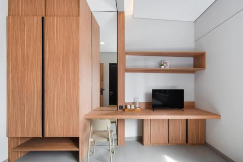 a room with a desk with a television on it at Cove Alexa in Jakarta