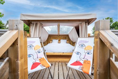 a bedroom with a bed and two chairs at Glamping Urrugne in Urrugne