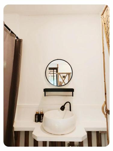 a bathroom with a white sink and a mirror at Ocam Ocam Bayside Lodge in Busuanga