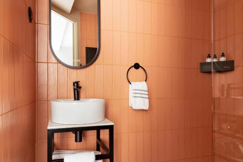 une salle de bains avec un lavabo et un miroir dans l'établissement La Dépendance, à Paris