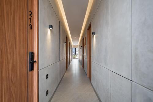 a hallway with white walls and a long hallway with wooden doors at Cove Alexa in Jakarta