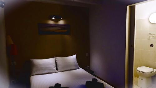 a small bedroom with a bed and a toilet at Auberge Saint Martin in La Brigue